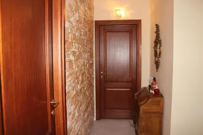 a hallway with a wooden door and a brick wall at Le Terrazze Del Vaticano in Rome