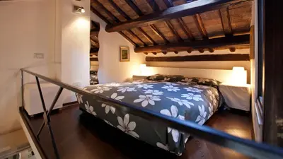 a bedroom with a large bed with flowers on it at Rental in Rome Loft Cappellari in Rome