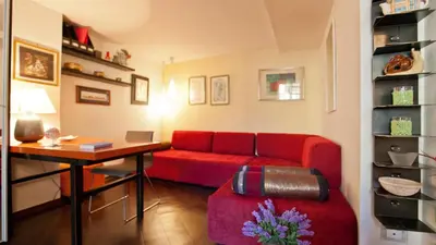 a living room with a red couch and a desk at Rental in Rome Loft Cappellari in Rome