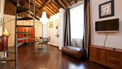 a living room with a couch and a television and a table at Rental in Rome Loft Cappellari in Rome