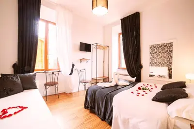 a bedroom with two beds and a table and chairs at Ostiense Suites in Rome