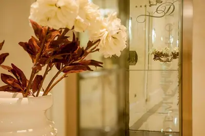 a white vase with flowers in it on a table at Demetra Hotel in Rome