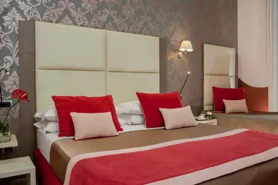 a bedroom with a large bed with red and white pillows at Demetra Hotel in Rome