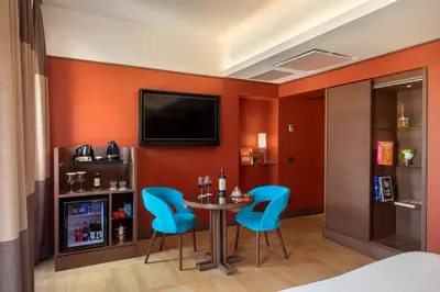 a room with a table and chairs and a tv at The Independent Hotel in Rome