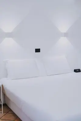 a white bed in a room at Albergo Delle Regioni, Barberini - Fontana di Trevi in Rome