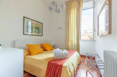 a bedroom with a bed with orange pillows and a window at Leonardo Suite Navona in Rome