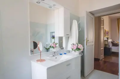 a white bathroom with a sink and a mirror at Leonardo Suite Navona in Rome