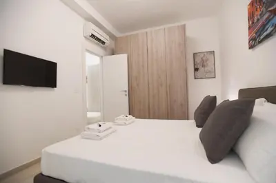 a bedroom with a white bed and a television at LATERANO 250 - COLOSSEO in Rome