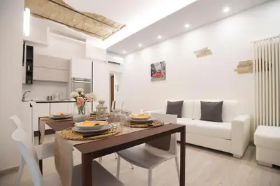 a kitchen and living room with a table and chairs at LATERANO 250 - COLOSSEO in Rome