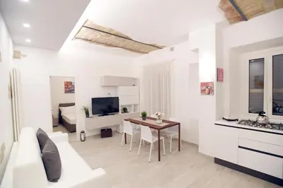 a white living room with a white couch and a table at LATERANO 250 - COLOSSEO in Rome