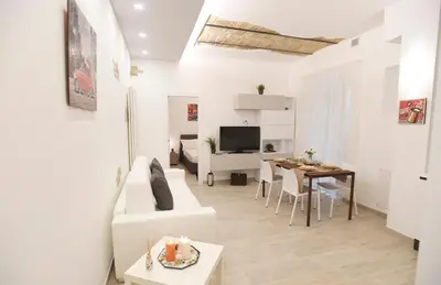 a living room with a table and a dining room at LATERANO 250 - COLOSSEO in Rome