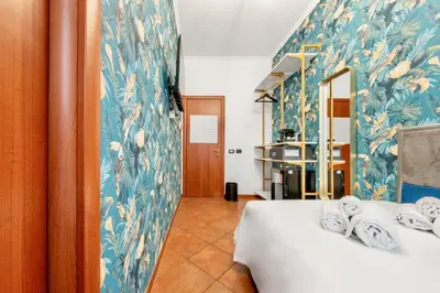 a room with two beds with blue and white wallpaper at Colosseo Relais in Rome