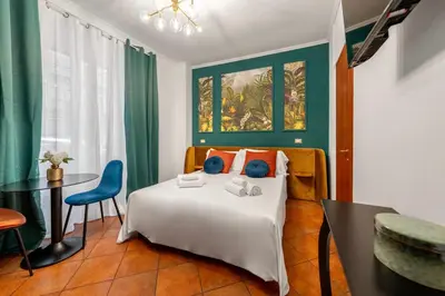 a hotel room with a bed and a table and chairs at Colosseo Relais in Rome