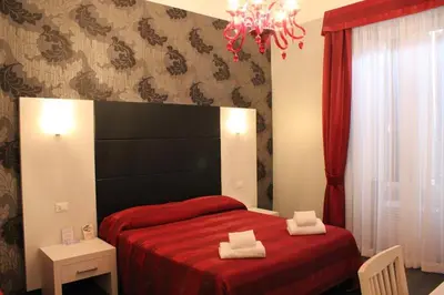 a bedroom with a red bed with two towels on it at Morfeo Suite in Rome