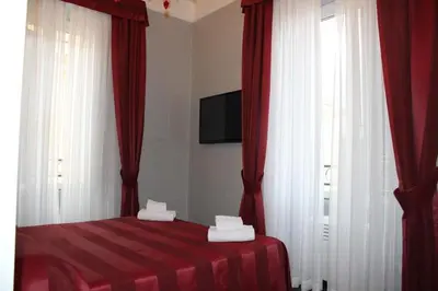 a bedroom with red and white curtains and a bed at Morfeo Suite in Rome
