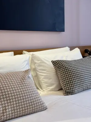 a bed with white sheets and pillows on it at STAY FINE Holiday’s House in Rome