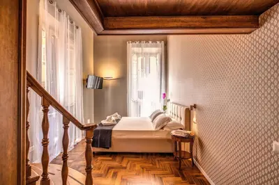 a small bedroom with a bed and a window at Elysium Suites collection in Rome