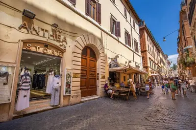 a group of people walking down a street with shops at The Spanish steps apartment 67 in Rome