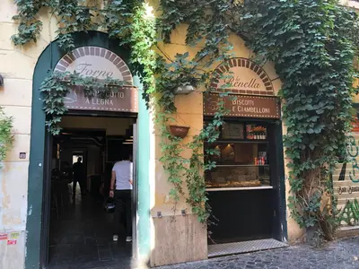 a person walking into a restaurant with ivy on the building at S.Apollonia Suite Trastevere in Rome