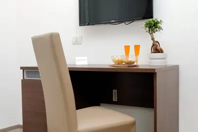 a desk with a chair and a tv on a wall at Victory Rooms in Rome