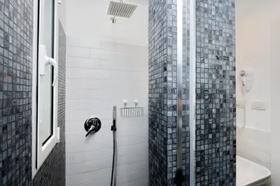 a bathroom with a glass shower with a toilet at Victory Rooms in Rome