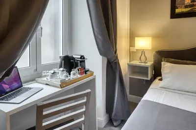 a bedroom with a desk with a laptop on it at Rhome Guest House in Rome