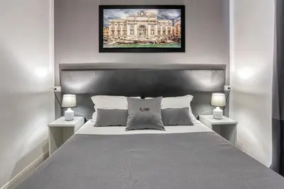 a bedroom with a large bed with two night stands at Rhome Guest House in Rome
