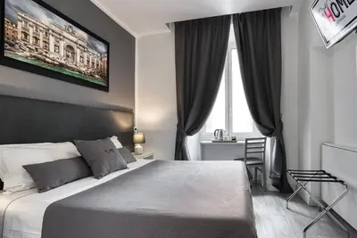 a bedroom with a large bed and a window at Rhome Guest House in Rome