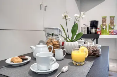 a table with cups of coffee and a glass of orange juice at Rhome Guest House in Rome