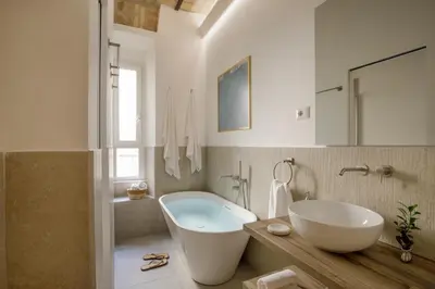 a bathroom with a large white tub and a sink at Rome for Two in Rome