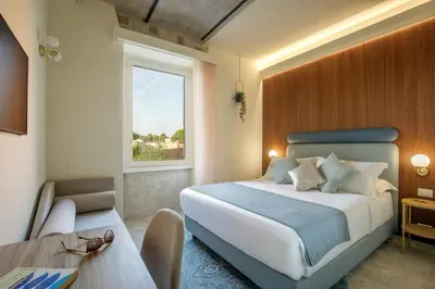 a bedroom with a bed and a desk and a window at Rome for Two in Rome