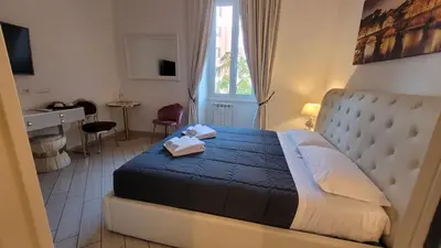 a bedroom with a bed and a desk and a window at Rome Central Rooms in Rome