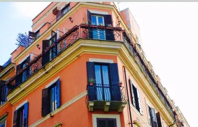 a tall orange building with balconies and windows at Golden Rooms Piazza di Spagna in Rome