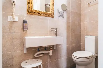 a bathroom with a toilet and a sink and a mirror at Golden Rooms Piazza di Spagna in Rome