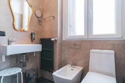 a bathroom with a toilet and a sink and a mirror at Golden Rooms Piazza di Spagna in Rome