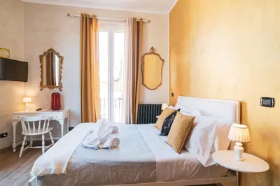 a bedroom with a bed with a baby on it at Golden Rooms Piazza di Spagna in Rome