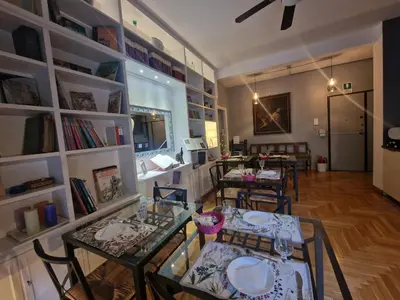 a room with tables and chairs and bookshelves at Sweet Home Parioli in Rome
