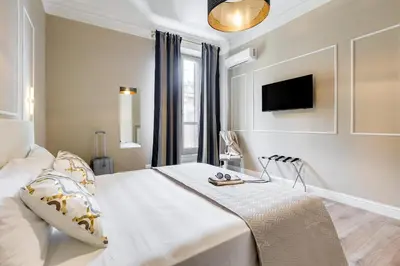 a white bedroom with a bed and a tv at Repubblica Exclusive Apartment in Rome