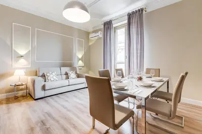 a dining room with a table and a couch at Repubblica Exclusive Apartment in Rome