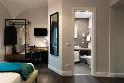 a bedroom with a bed and a bathroom with a mirror at Lungotevere Ripa in Rome