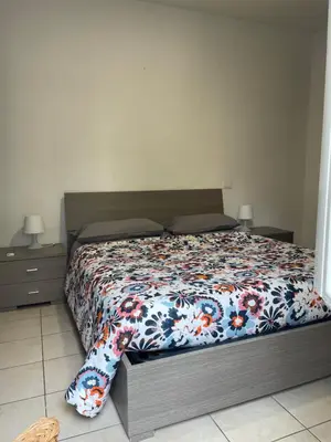 a bedroom with a bed with a floral comforter at Appiolatino - Il Fenicottero in Rome