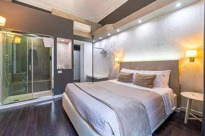 a bathroom with a sink and a toilet and a bed at Four Rivers Suites in Rome