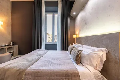 a small bathroom with a sink and a bed at Four Rivers Suites in Rome