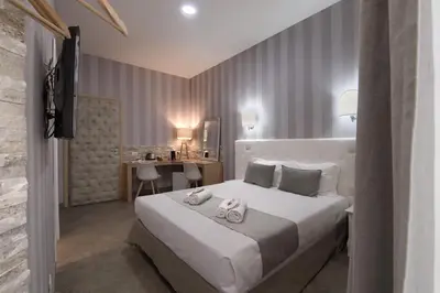 a bedroom with a large white bed and a desk at Vatican Treasure in Rome