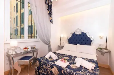 a bedroom with a blue and white bed and a window at Roma Charming Rooms in Rome
