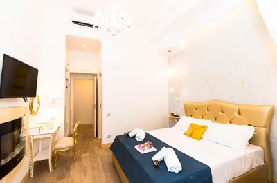a bedroom with a bed and a table and a television at Roma Charming Rooms in Rome