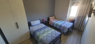 a small room with two beds and a window at Hello Roma B&B in Rome
