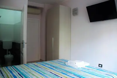 a bedroom with a bed with a tv on the wall at Hello Roma B&B in Rome
