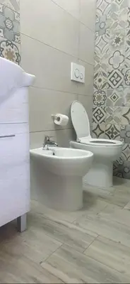 a white bathroom with a toilet and a sink at Hello Roma B&B in Rome