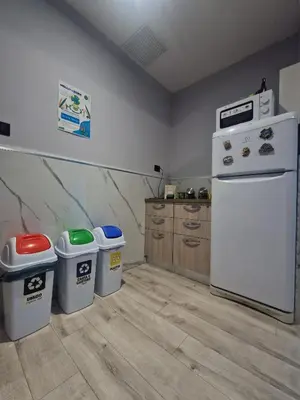 a kitchen with a white refrigerator and two trash cans at Hello Roma B&B in Rome